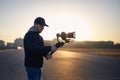 Man filming with camera and gimbal against city at sunrise Royalty Free Stock Photo