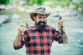 Young man fishing. Fisherman with rod, spinning reel on river bank. Man catching fish, pulling rod while fishing on lake Royalty Free Stock Photo