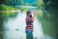 Young man fishing. Fisherman with rod, spinning reel on river bank. Man catching fish, pulling rod while fishing on lake Royalty Free Stock Photo