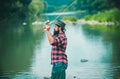 Young man fishing. Fisherman with rod, spinning reel on river bank. Man catching fish, pulling rod while fishing on lake Royalty Free Stock Photo