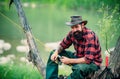 Young man fishing. Fisherman with rod, spinning reel on river bank. Man catching fish, pulling rod while fishing on lake Royalty Free Stock Photo