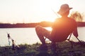 Young man fishing on lake at sunset enjoying hobby Royalty Free Stock Photo