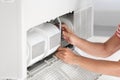 Young man fixing air conditioner at home