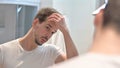 Young Man Fixing Hair in Mirror Royalty Free Stock Photo