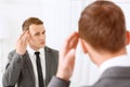 Young man fixing his hair in front of mirror Royalty Free Stock Photo