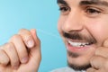 Young man flossing teeth on color background Royalty Free Stock Photo