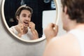 young man flossing teeth near mirror Royalty Free Stock Photo