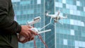 A young man a man controls a quadrocopter with a modern control panel and an RC transmitter. Man flying and filming with