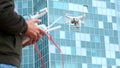 A young man a man controls a quadrocopter with a modern control panel and an RC transmitter. Man flying and filming with