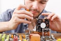 Young Man Repairs Computer Hardware While Sitting at a Wooden Table Royalty Free Stock Photo