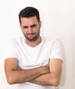 Young man with folded hands, looks angry Royalty Free Stock Photo