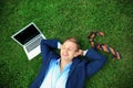 Young man in formal clothes relaxing on green grass outdoors Royalty Free Stock Photo