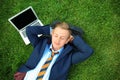 Young man in formal clothes relaxing on green grass outdoors Royalty Free Stock Photo