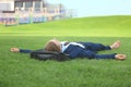 Young man in formal clothes relaxing on green grass outdoors Royalty Free Stock Photo