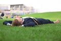 Young man in formal clothes relaxing on green grass outdoors Royalty Free Stock Photo