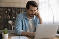 Young man freelancer concentrate on solving business problem using laptop