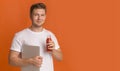 Young man freelancer holding laptop and drinking red healthy detox smoothie