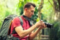 Travel backpacker photographer with camera in hand make photo on nature background Royalty Free Stock Photo