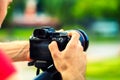 Travel photographer with camera in hand make photo on nature background Royalty Free Stock Photo