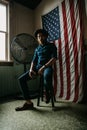 Man with beard sitting in room with an American flag