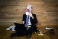 Young man in funny rubber mask sits on the floor