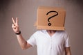 Young man gesturing with a cardboard box on his head with question mark