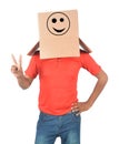 Young man gesturing with a cardboard box on his head with smiley Royalty Free Stock Photo