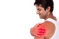 Young man get hurt, pain and suffering in shoulder, touching his shoulder with red dot, isolated on white background, copy space.