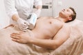 Young man getting endospheres massage at beauty clinic