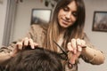 Young man getting a modern haircut. Girl hairdresser cuts a guy with scissors. Men's fashion and style. Hair care Royalty Free Stock Photo