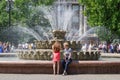 The young man and the girl in the city park near the fountain