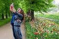 A young man and a girl with glasses taking pictures of themselves with a smartphone