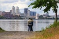 A young man and girl are standing and hugging on a cloudy morning on the background of Dnieper and skyscrapers. Spring, summer Royalty Free Stock Photo