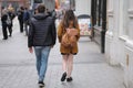 A young man and a girl walk along the sidewalk