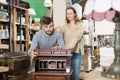 Man with girlfriend admiring vintage wooden bureau