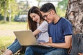 Young man and girls friend classmates sitting at park under tree Royalty Free Stock Photo