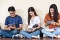 Young man and girls friend classmates sitting useing technology Royalty Free Stock Photo