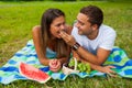 Young man gives grape to his girlfriend. He feeds her Royalty Free Stock Photo