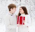 Young man gives a present to his girlfriend for Christmas