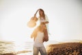 Young man giving piggyback ride to girlfriend on beach. Young couple enjoying summer holidays Royalty Free Stock Photo