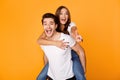 Young man giving piggyback ride to woman, showing peace sign Royalty Free Stock Photo