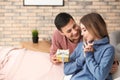 Young man giving present to his beloved girlfriend at home