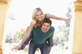 Young Man Giving Woman Piggyback Outdoors Royalty Free Stock Photo