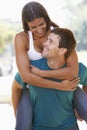 Young Man Giving Woman Piggyback Outdoors Royalty Free Stock Photo