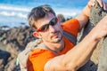 Young man in glasses with backpack climbing Royalty Free Stock Photo