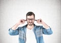 Young man in glasses covering ears Royalty Free Stock Photo
