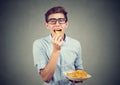 Young man in glasses eating potato chips Royalty Free Stock Photo