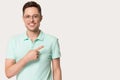 Young man in glasses looking at camera pointing finger aside Royalty Free Stock Photo