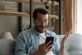 Man holds cellphone gawp at screen read news feels surprised