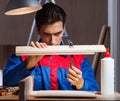 Young man gluing wood pieces together in DIY concept